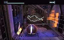 A metallic ball stands in a futuristic corridor, with sparks of electricity in the background. Atop the image is a bar and a number indicating the health of the player, and three round icons indicating the remaining bombs.