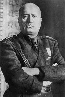official portrait of Mussolini in uniform with crossed arms