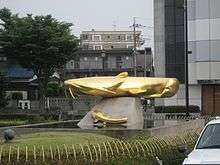 A picture of a fountain or sculpture of an Amur catfish, in Japan: The catfish is about 4 m long atop the fountain.