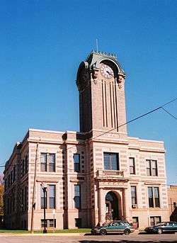 A large sandstone building with a central clock tower