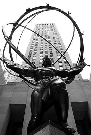 A statue of a muscular man holding a hollow globe on his shoulders. A skyscraper towers above the statue in the background.