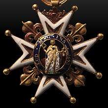 Photo of a medallion with Saint Louis in gold armor in the center surrounded by a blue oval and set amid four arms of a white-enameled cross and four gold fleur de lis