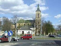 Colour picture of a road intersection, with a large neo-classical church in the background