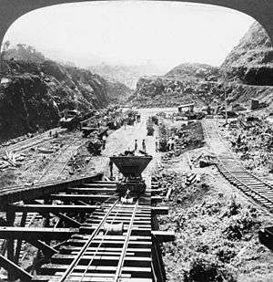 Large excavation through mountains, seen from a rail tunnel