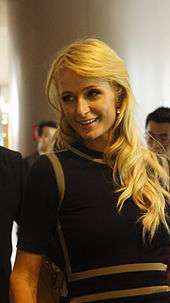 Smiling blonde woman in dark clothing