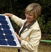 Former PGE CEO Peggy Fowler in a portrait with a solar panel.