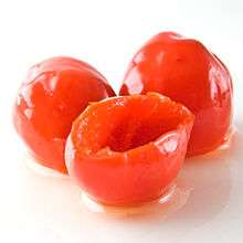 Three red peppadew peppers glisten with moisture