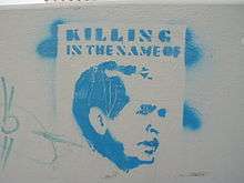 An image of George W. Bush stencilled in light blue with the words "Killing in the Name of" written above it.