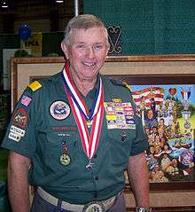 man in Venturer uniform with medals, painting in background