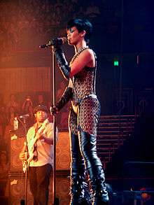 A young woman performing on a microphone while wearing a see-through outfit