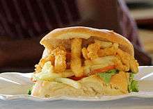 A close-up view of a personal-sized Gatsby sandwich prepared with calamari and chips
