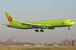 An S7 Airlines Boeing aircraft with wheels down on final approach to land