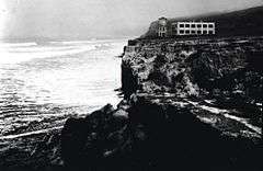 Historic photograph of the Old Scripps Building, a rectangular structure on a clifftop overlooking the Pacific breakers.