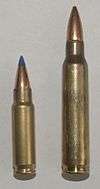 Photo of the 5.7×28mm SS197SR cartridge next to a 5.56×45mm NATO cartridge. The 5.56×45mm cartridge is significantly larger.