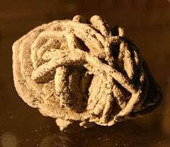 A rough, oval desert rose formation made up of barite crystals.