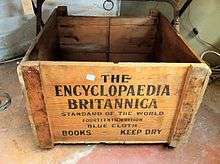 A wooden crate reading "THE / ENCYCLOPAEDIA / BRITANNICA / STANDARD OF THE WORLD / FOURTEENTH EDITION / BLUE CLOTH / BOOKS KEEP DRY"