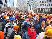Large group of Sikh men and women on a city street