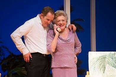 Todd McKenney with his arm over Nancye Hayes's shoulder as she takes a telephone call during a performance of the play Six Dance Lessons in Six Weeks