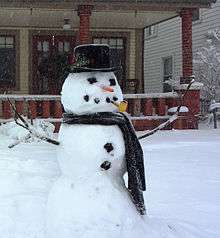 Photograph of a classic-style snowman in scarf and hat with pipe and carrot nose, in Winona Lake, Indiana, USA