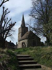 A flight of steps leads up to a stone church with a tower and steeple