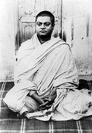 Vivekananda sitting, wearing white shawl