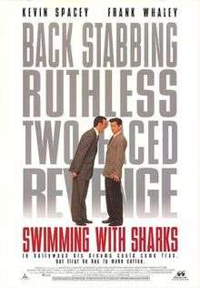 A man towering over another shouting, the words Swimming with Sharks filling the background