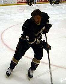 Selänne focuses on the puck as he skates in the corner