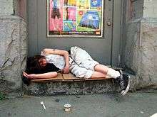 A young person sleeping in a doorway in a DTES alley