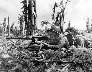 Three Marines and their machine gun lay heavy fire on a Japanese sniper nest (July 28, 1944).