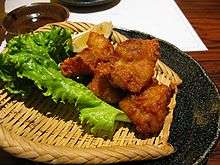 Japanese-style fried chicken on a plate alongside some lettuce