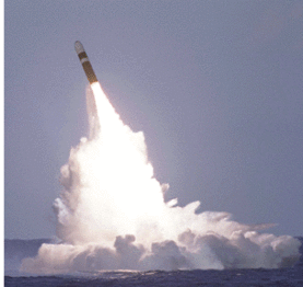 Blunt-nosed missile, with its rocket motors fired, splashes huge white waves as it positions itself on an angle for a ballistic firing.
