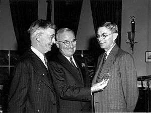 Three smiling men in suits