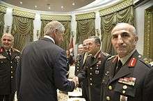 Mr Hagel, in civilian suit, shakes hands with General Öztürk, in uniform.