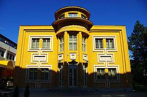 a colour photograph of an imposing yellow two storey building