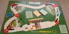 The start of a game of Waddington's Formula 1 showing board, playing pieces, card packs and dice.