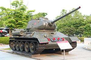 A large, heavily armed and armored tank outside a modern-day museum