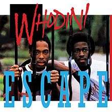 Two members of Whodini looking through a wrought-iron fence