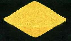 A yellow sand-like rhombic mass on black background.