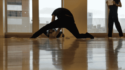 a person stretches their legs to reach a shape in the floor